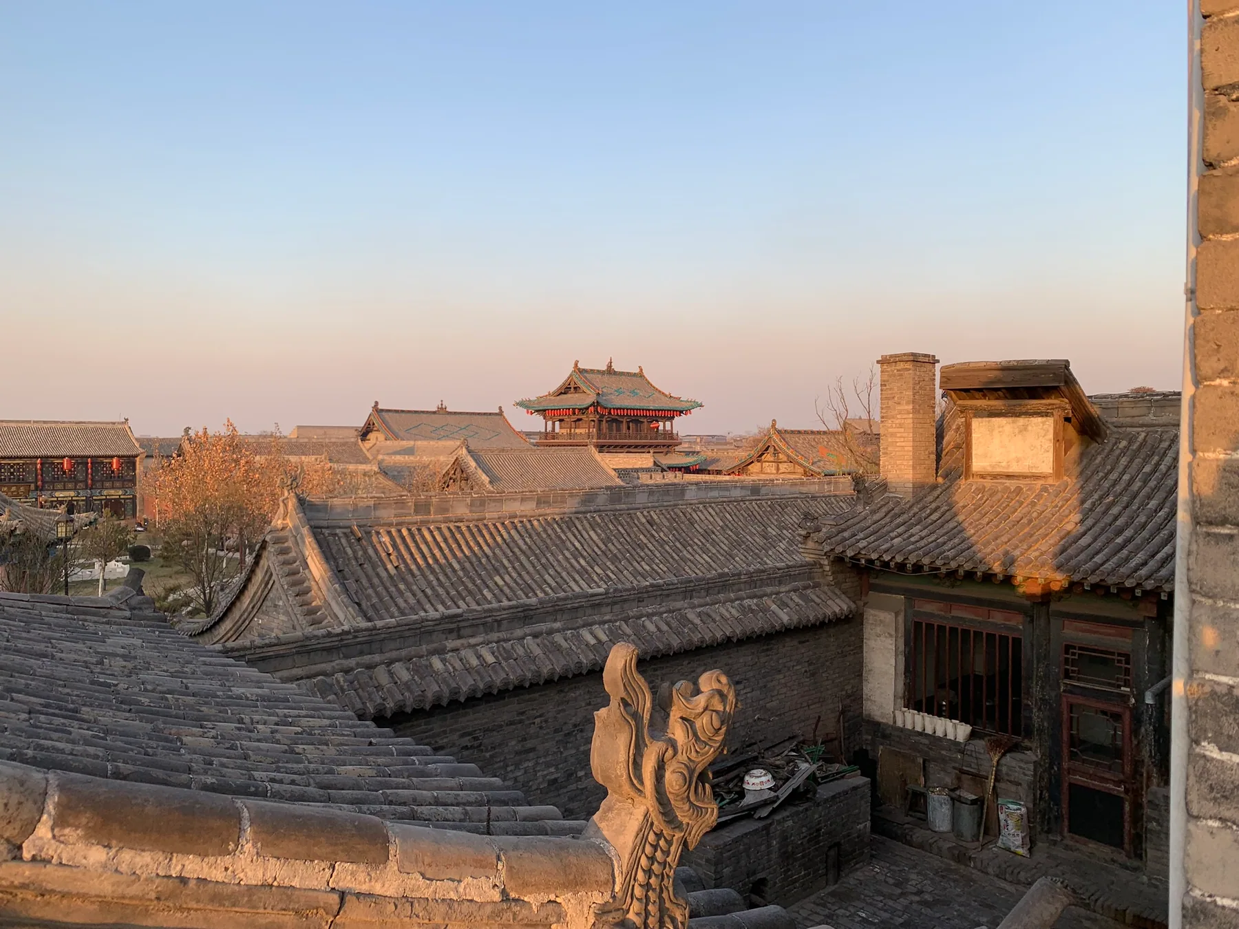Old Pingyao rooftops glowing in late afternoon light.