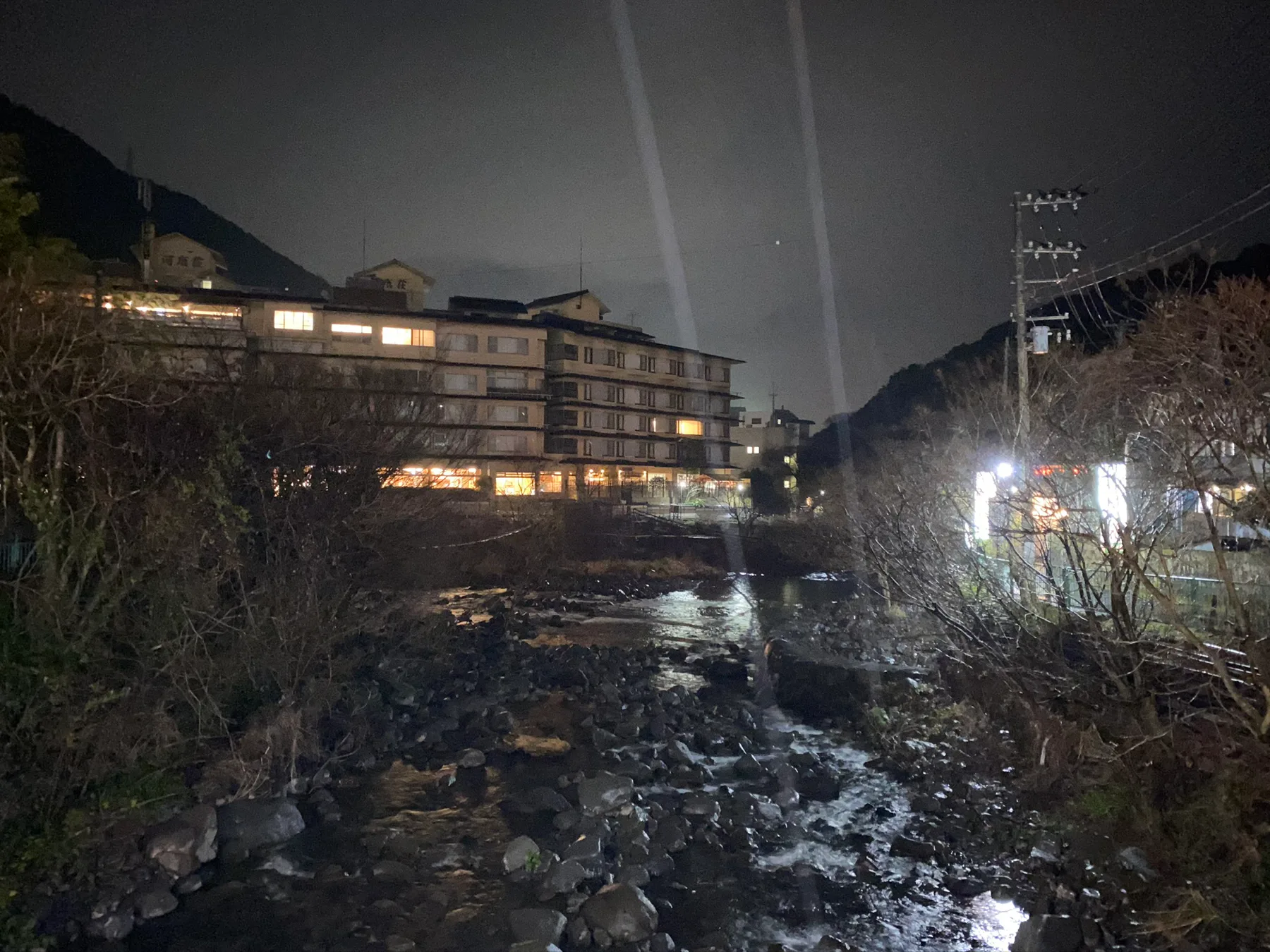 Building lights beside water in Hakone at night.