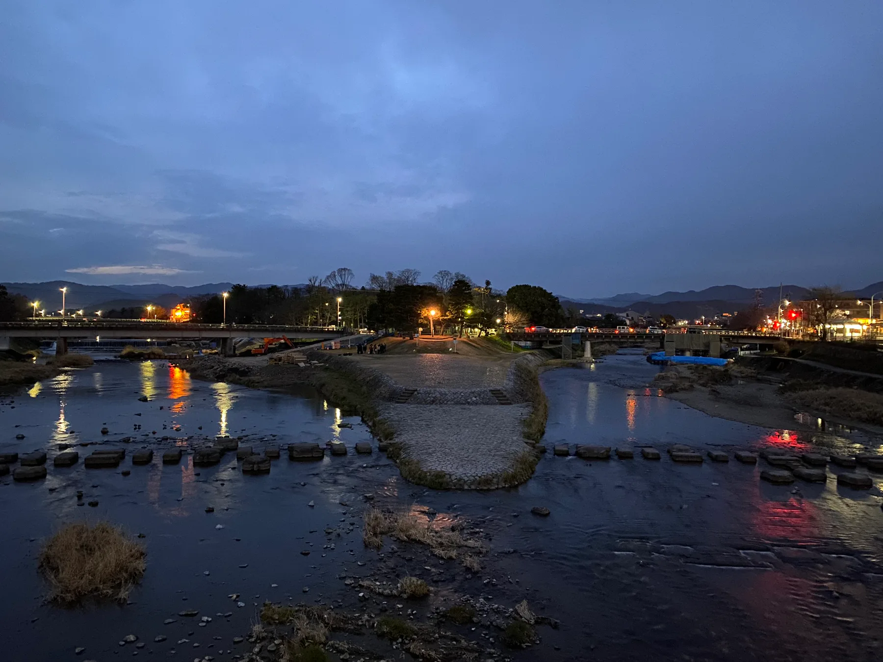 Kyoto river and city lights at dusk.