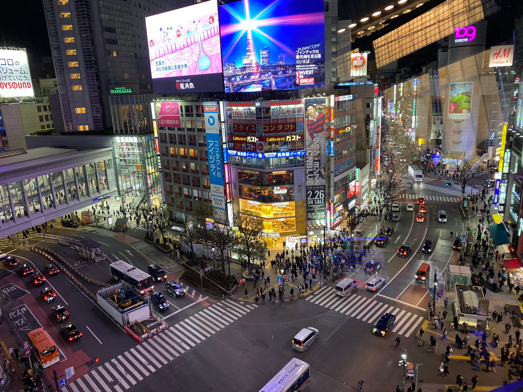 Shibuya Crossing glowing at night in Tokyo.