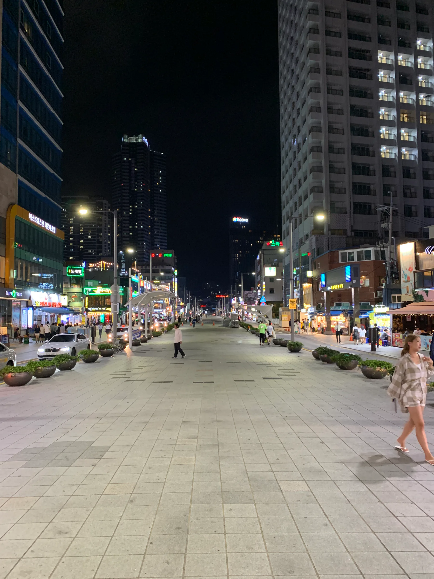 A wide city street in Busan after dark.