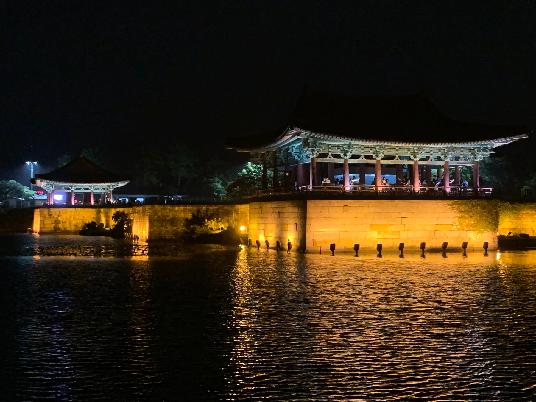 A lit pavilion reflected across water in Gyeongju at night.