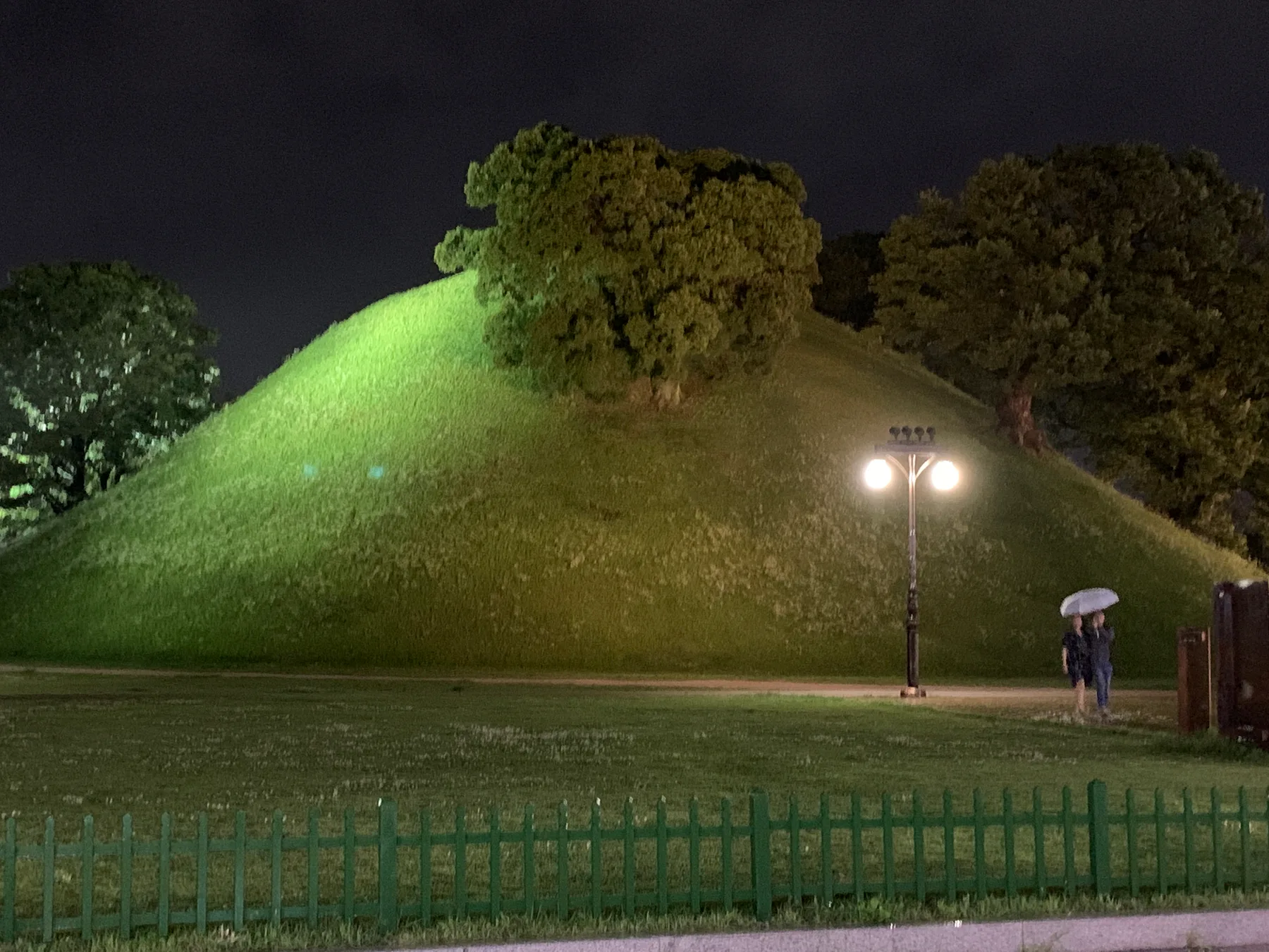 A royal tomb mound lit at night in Gyeongju.