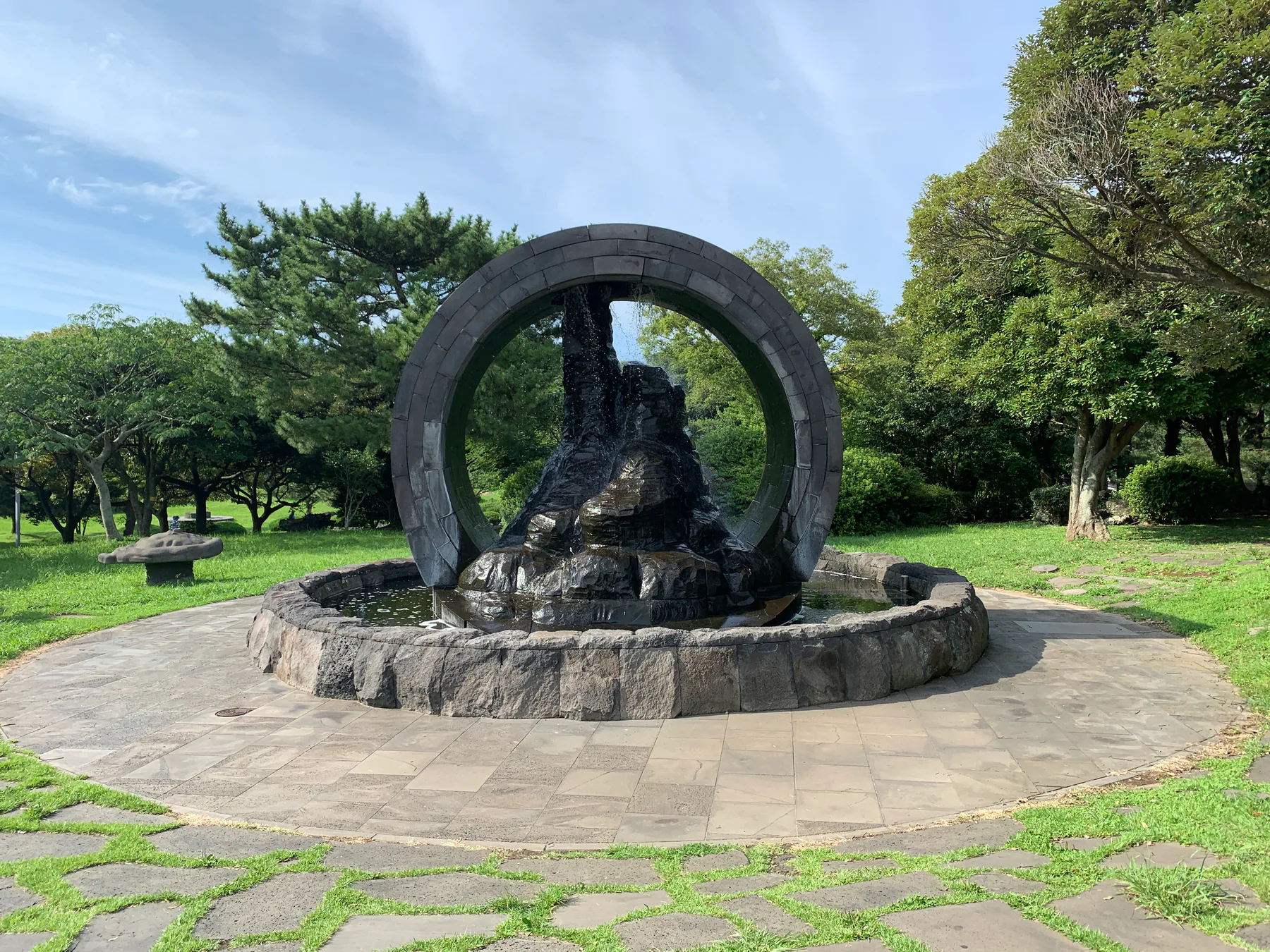 A green park landscape and stone monument in Jeju.