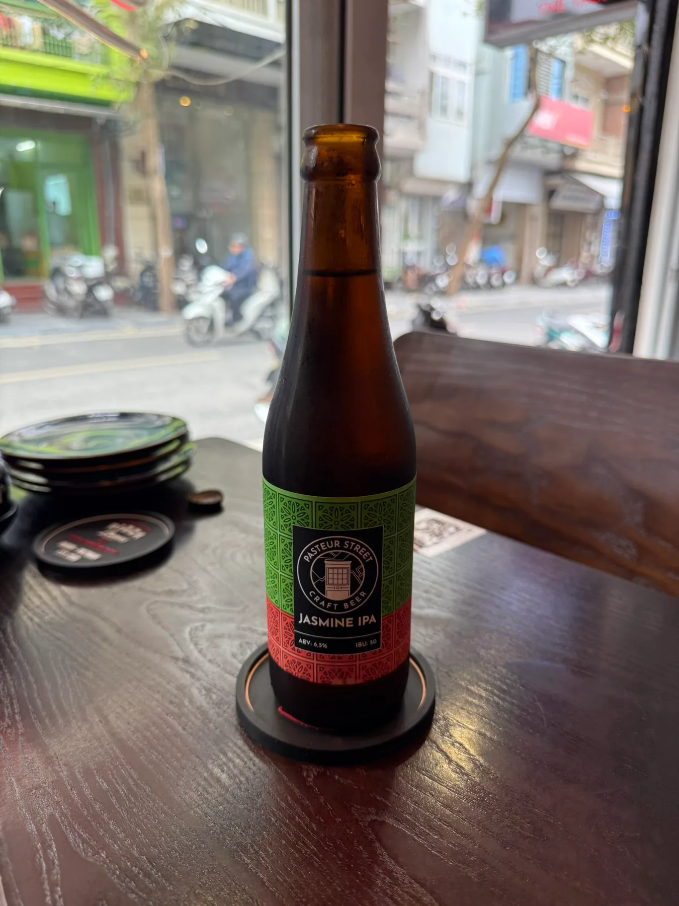 A final beer on a table beside a Hanoi window.
