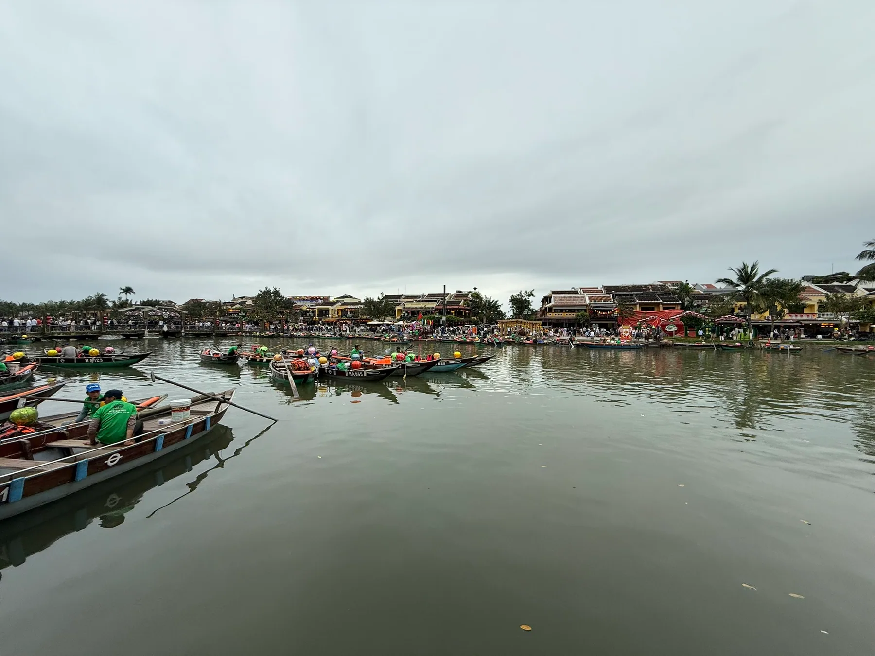 Riverside boats and low buildings along the water in Hội An.